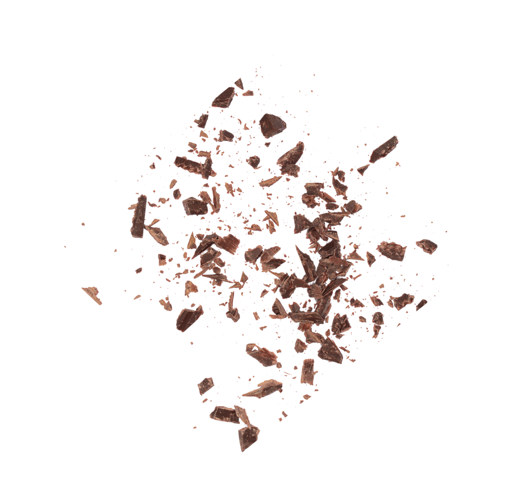 Scattered chocolate shavings on a white background, showcasing natural, maple-sweetened ingredients for kids snacks.