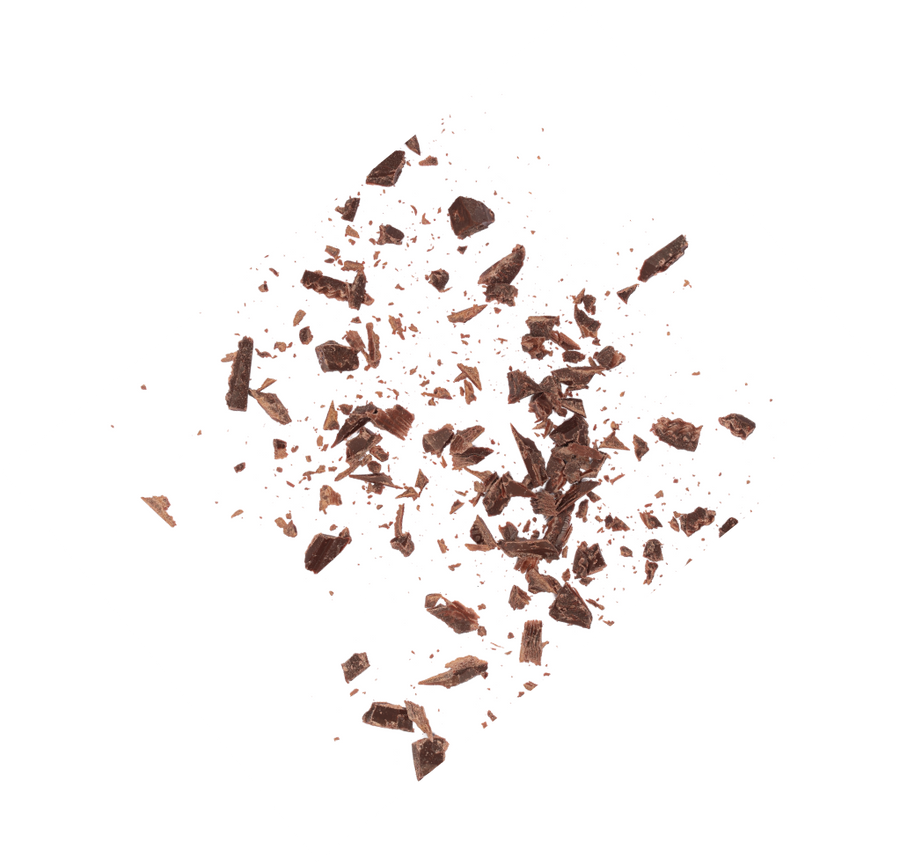 Scattered chocolate shavings on a white background, showcasing natural, maple-sweetened ingredients for kids snacks.