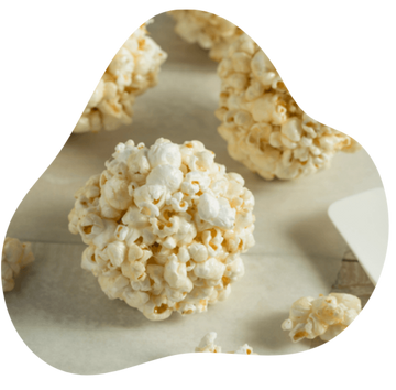 Popcorn on a white plate with a wooden surface